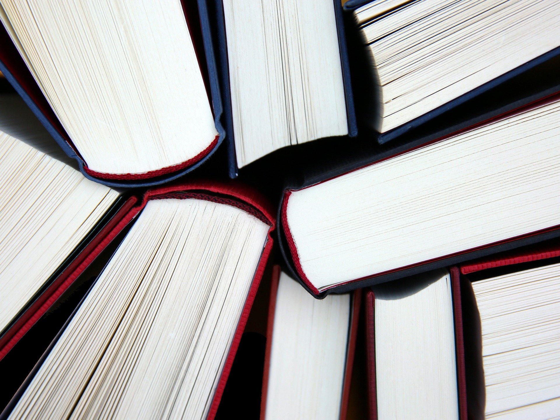 Several hardback books are arranged in a circular pattern, their pages and spines intersecting to create a visually striking geometric composition—an artistic nod to Understanding Your Child’s Curriculum.