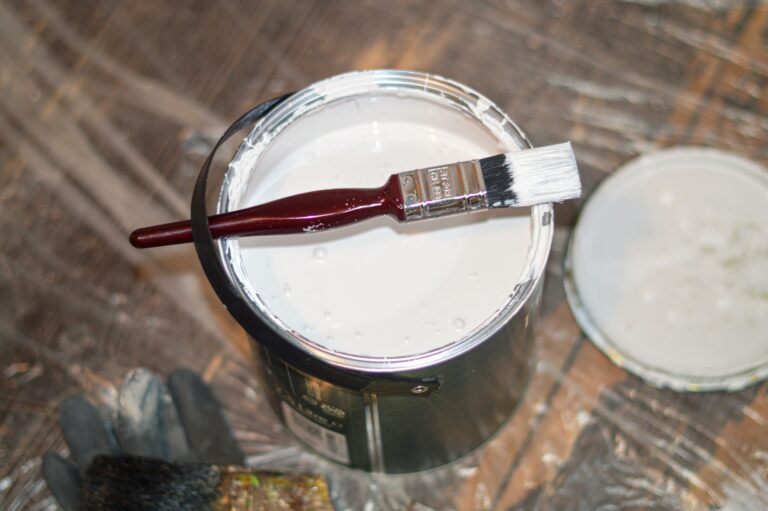 a paintbrush sat on a tin of opened paint