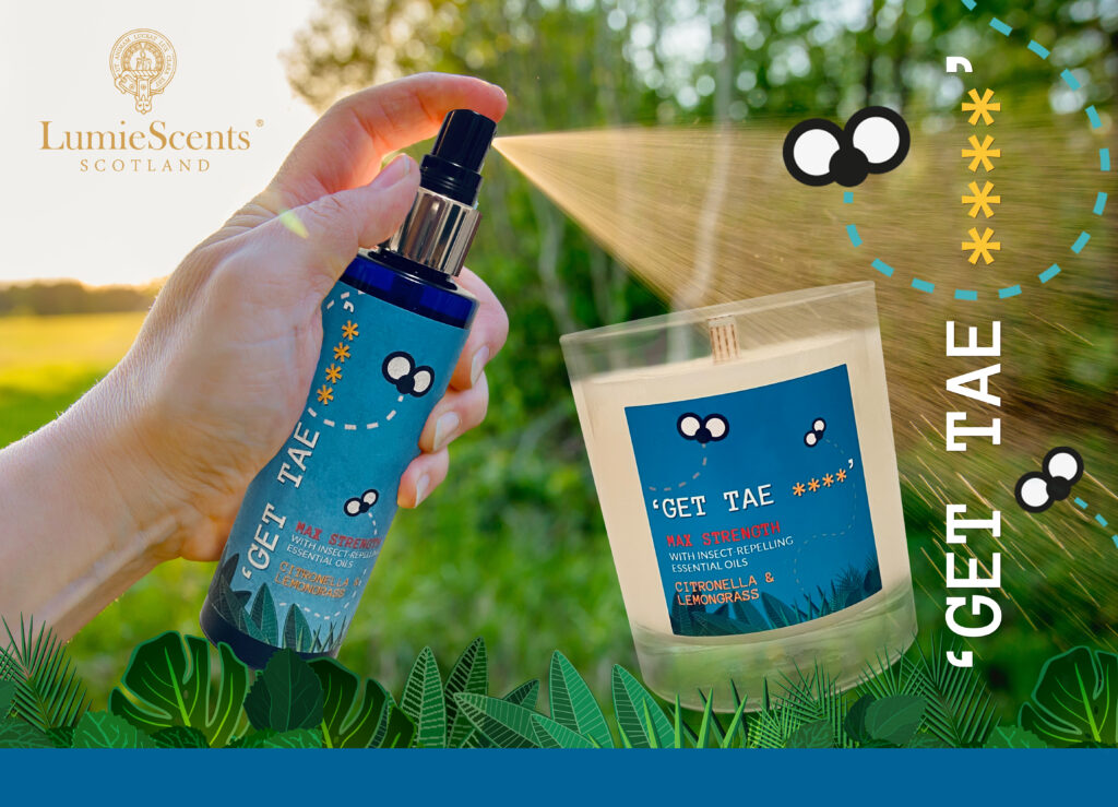 A hand sprays a blue bottle labelled "GET TAE" beside a matching candle by LumieScents Scotland. The scene, set amid green foliage and playful insect graphics, promotes the Summer Prize Giveaway from Top UK Bloggers.