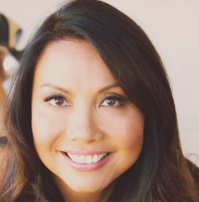 A woman with long dark hair and brown eyes is smiling at the camera. She has smooth skin and is photographed in soft, natural light—her look perfectly embodying the effortless style seen in many High-Heel Mules: Dos and Don’ts guides.