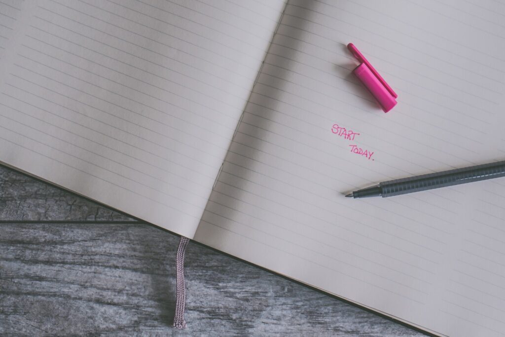 An open lined notebook lies on a wooden surface. A pink highlighter cap, black pen, and the words "START TODAY." written in pink ink suggest jotting down Self Care Tips For Autumn on the right-hand page.