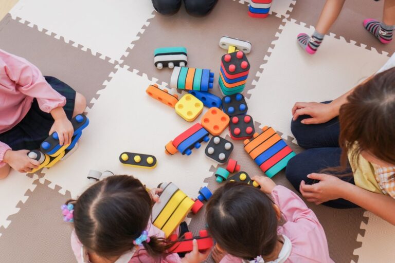 children playing in nursery school with coloured blocks