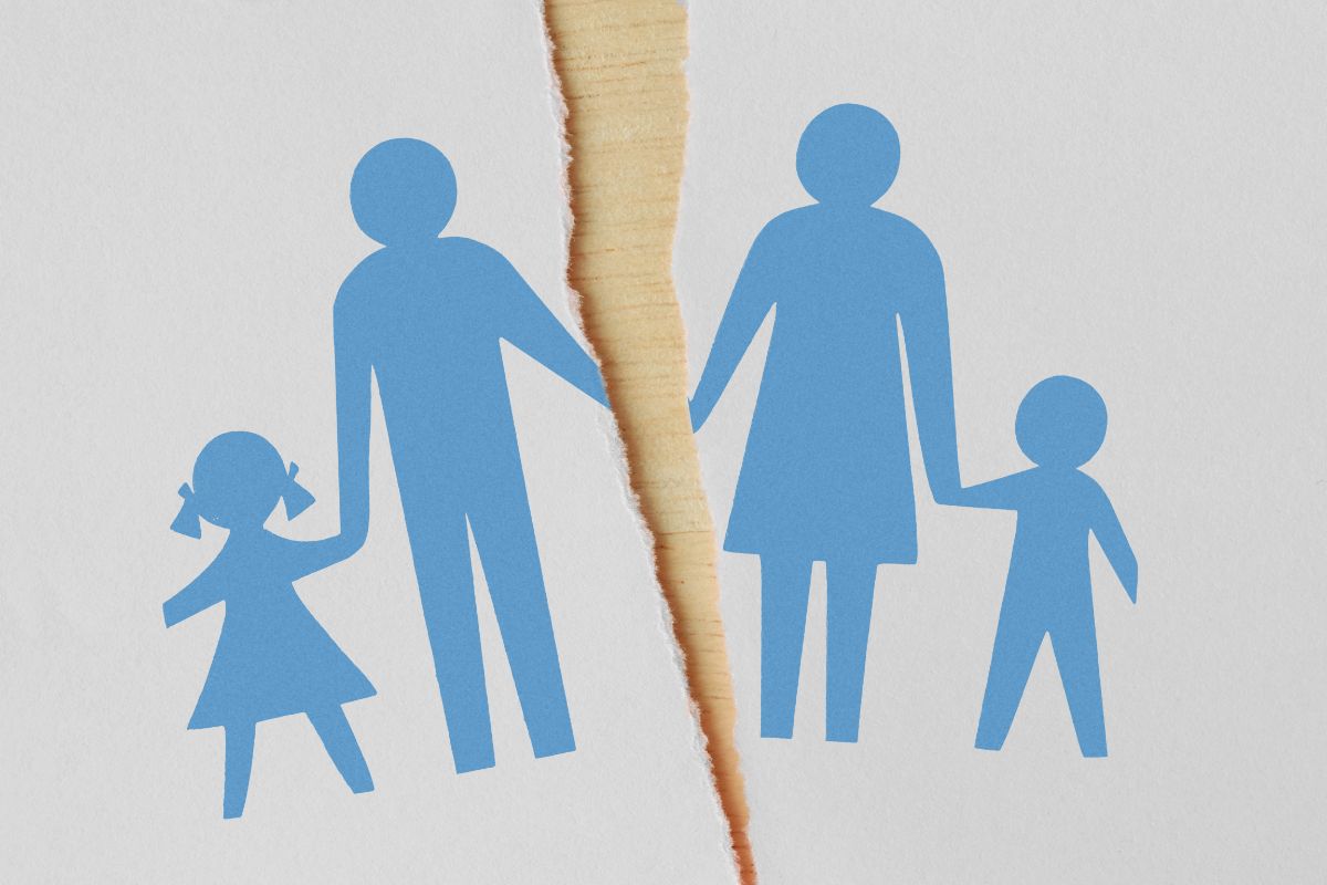 A blue silhouette illustration of a family holding hands, torn in half by a jagged rip—symbolising the complex emotional impact surrogacy can have on parents and children—set against a white background.