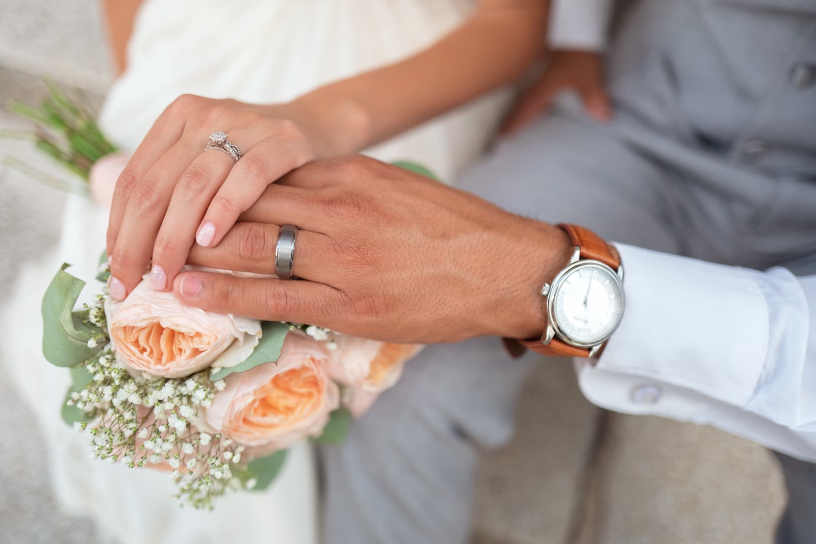A man and woman holding hands, sharing a tender moment on their wedding day.