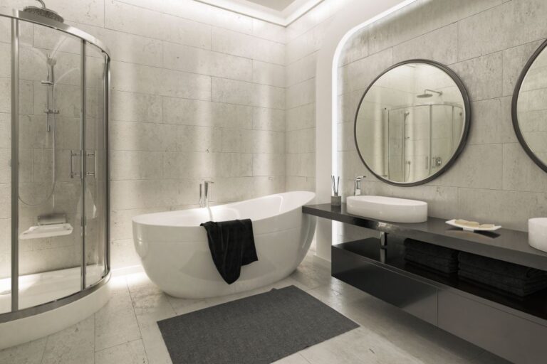 Modern bathroom remodelling with a freestanding white bath, black towel, glass-enclosed shower, two round mirrors, vessel basin, black worktop, and neatly folded black towels on open shelves beneath the counter.