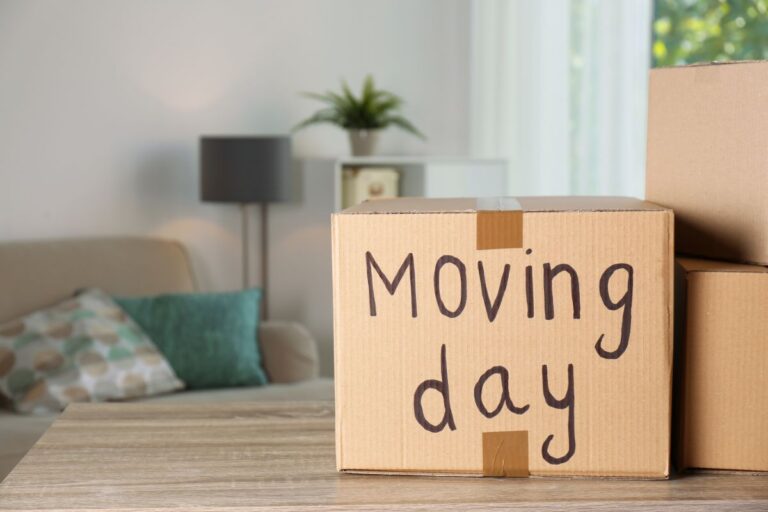 Cardboard boxes labelled “Moving day” sit on a living room table, ready for a stress-free family house move.